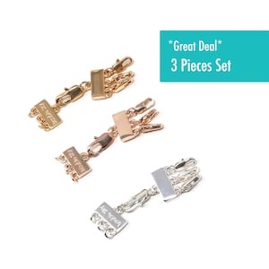 May include: A set of three gold, rose gold, and silver necklace extenders. Each extender has a rectangular tag with the words "Las Vegas" engraved on it. The extenders are designed to add length to necklaces and are sold as a set of three.