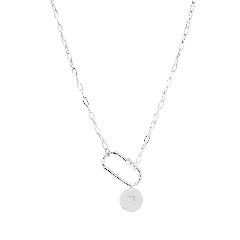 May include: Silver chain necklace with a silver carabiner clasp and a silver disc charm with the letter 'B' engraved on it.