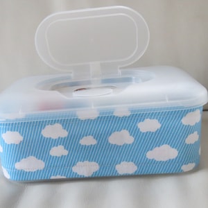 Könnte beinhalten: Ein durchsichtiger Plastikbehälter mit Deckel, verziert mit einem blauen und weißen Stoff mit Wolkenmuster. Der Deckel ist geöffnet und der Behälter ist leer.