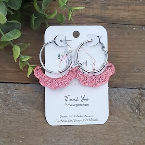 May include: Pink glitter hoop earrings with a scalloped edge. The earrings are on a white card with the text "Thank You for your purchase" and contact information for Blessed Stitch Studio.