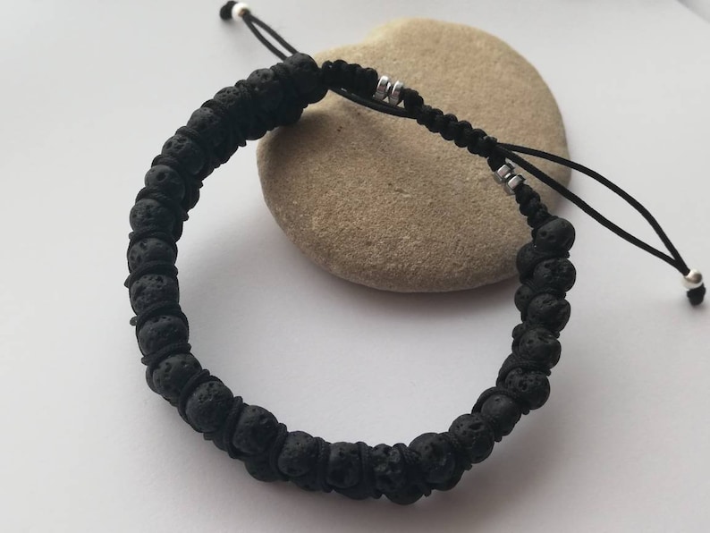 Puede incluir: Pulsera de roca volc&aacute;nica negra con cord&oacute;n negro ajustable y detalles plateados. La pulsera presenta cuentas de lava redondas y texturizadas. El dise&ntilde;o ajustable permite un ajuste c&oacute;modo. Un accesorio sencillo y natural.