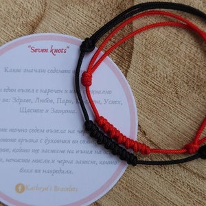 May include: Two red and black string bracelets with seven knots each. The bracelets are tied together and are on a white card with text in Bulgarian that reads "Seven knots" and explains the meaning of the knots. The card also includes a Facebook logo and the text "Kathryn's Bracelets".