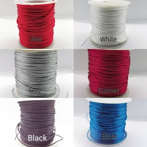 May include: Spools of cord in various colors, including red, white, gray, garnet, black, and blue. The spools are labeled with the color of the cord.