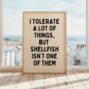 May include: A framed print with a white background and black text that reads "I tolerate a lot of things, but shellfish isn't one of them."