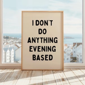 Op de afbeelding: Een beige ingelijste poster met zwarte tekst die "Ik doe niets avond-gebaseerd" zegt.