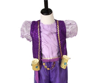 May include: A purple and gold costume for a child, displayed on a mannequin. The outfit includes a lavender top, a sequined vest with gold trim, and matching purple pants. Accessories include gold wrist cuffs and a decorative belt.