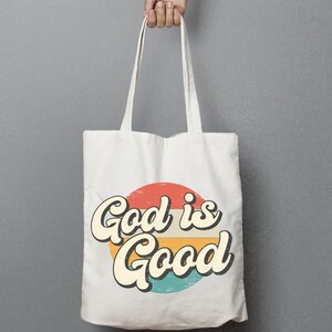 May include: White canvas tote bag with a retro-style graphic of a red, orange, yellow, and blue circle with the text "God is Good" in a vintage font.
