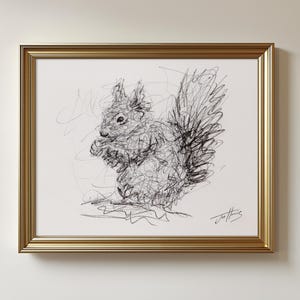 May include: A framed artwork featuring a pen and ink sketch of a squirrel. The squirrel is depicted in a scribbled style, with a fluffy tail and a detailed face. The artwork is framed in a gold-colored frame.