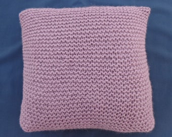 May include: A soft, knitted pillow in a light purple color. The pillow is square shaped and has a simple, textured design.