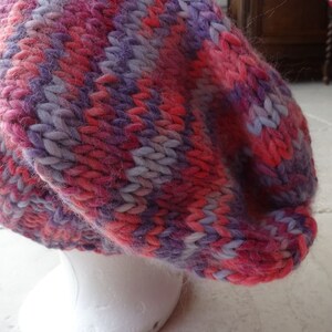May include: A pink and purple striped knitted beanie hat.