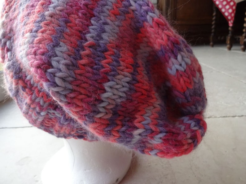 May include: A pink and purple striped knitted beanie hat.