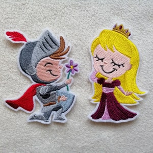 Könnte beinhalten: Gestickter Bügelaufkleber mit einem Cartoon-Ritter in Rüstung, der eine Blume hält, und einer Prinzessin mit Krone und langen blonden Haaren. Der Ritter trägt einen roten Umhang und die Prinzessin ein violettes Kleid.