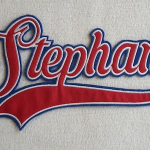 Könnte beinhalten: Roter und blauer gestickter Aufnäher mit dem Namen "Stephan" in weißer Umrandung und einem geschwungenen Design.