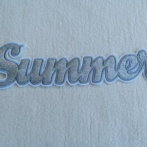 Könnte beinhalten: Silberner Glitzer-Aufbügel-Patch mit dem Wort "Summer" in einer kursivschrift.