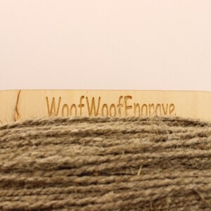 May include: A spool of natural brown twine with a wooden label that reads "Woof Woof Engrave".