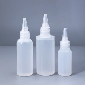 Puede incluir: Tres botellas de plástico transparente con puntas puntiagudas, dispuestas en fila de mayor a menor. Las botellas están vacías y parecen estar hechas de un material translúcido.