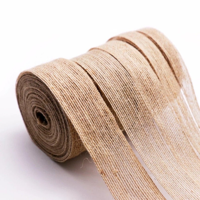 Op de afbeelding: Een rol natuurlijke bruine juteband. Het lint is geweven en heeft een ruwe textuur. Het is perfect om een rustieke touch toe te voegen aan ambachten, geschenken en huisdecoratie.