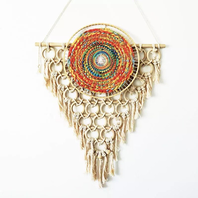 May include: A colorful woven wall hanging with a circular design and a fringe of tassels. The hanging is made of natural materials and has a bohemian style.