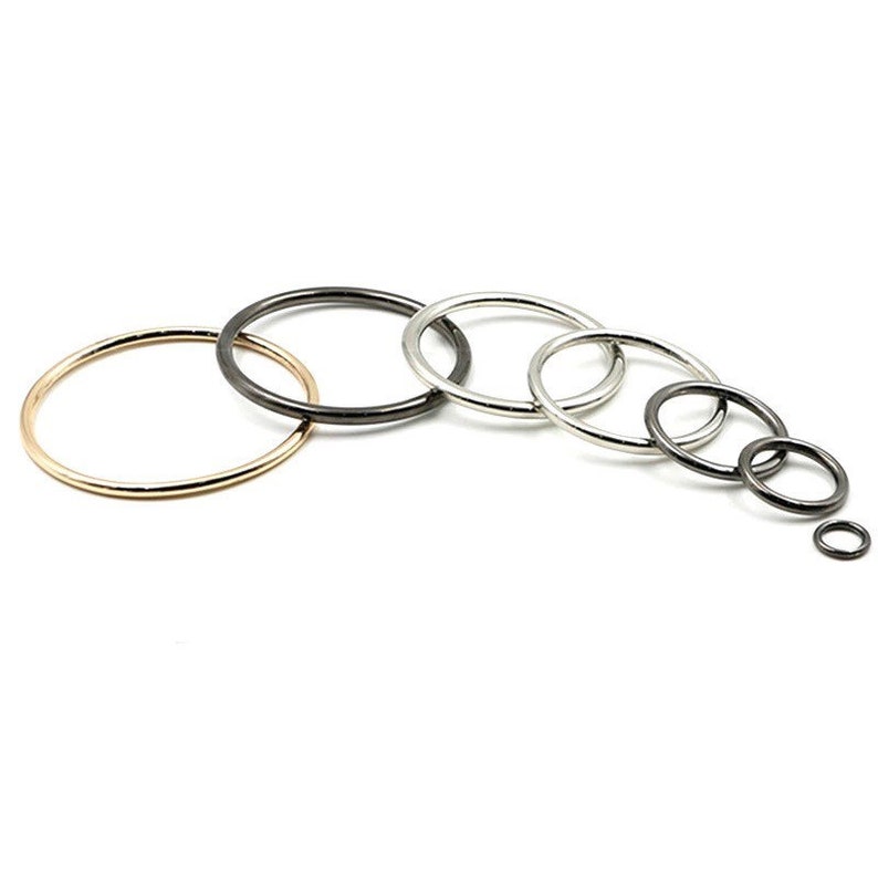 May include: A set of seven metal jump rings in various sizes. The rings are in gold, silver, and black.