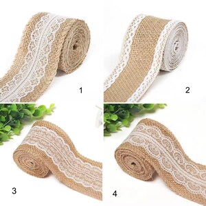 May include: Four rolls of tan burlap ribbon, each featuring a distinct white lace trim pattern along the center or edge. The textured, woven fabric of the burlap contrasts with the intricate, delicate white lace designs on each individual spool.