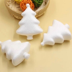 May include: Three white foam Christmas tree shapes. The trees are about 2 inches tall and are perfect for crafting.