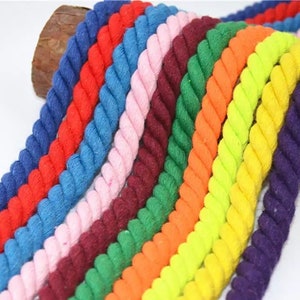 May include: A collection of colorful cotton ropes in various shades, including red, blue, pink, green, orange, yellow, and purple. The ropes are arranged in a rainbow pattern and are made of a soft, natural material.