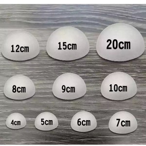 May include: Nine white half-sphere shapes with black text indicating their diameter in centimeters. The diameters are 4cm, 5cm, 6cm, 7cm, 8cm, 9cm, 10cm, 12cm, 15cm, and 20cm.