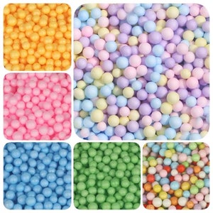 Peut inclure: Assortiment de boules de mousse colorées dans différentes couleurs, y compris le jaune, le rose, le bleu clair, le vert et un mélange de couleurs pastel.