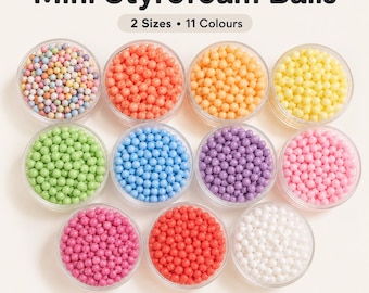 May include: Eleven clear circular containers filled with mini styrofoam balls in various solid colors and one multi-colored mix. The text "Mini Styrofoam Balls" and "2 Sizes • 11 Colours" is displayed at the top of the image.