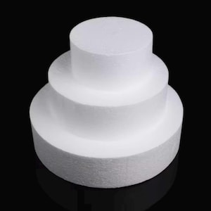 May include: Three round white styrofoam cake dummies stacked on top of each other. The bottom dummy is the largest, the middle dummy is the medium size, and the top dummy is the smallest.