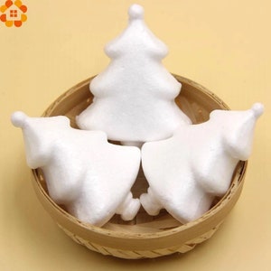 May include: Three white foam Christmas tree shapes in a woven basket. The trees are blank and ready to be decorated.