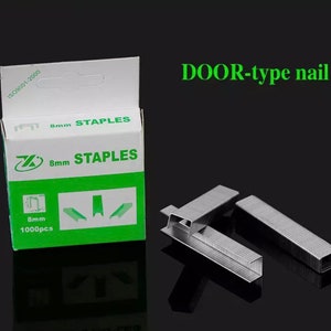 May include: A box of 8mm staples with the text "8mm STAPLES" in green and white. The box also has the text "1000pcs". Several loose staples are next to the box. The text "DOOR-type nail" is above the staples.