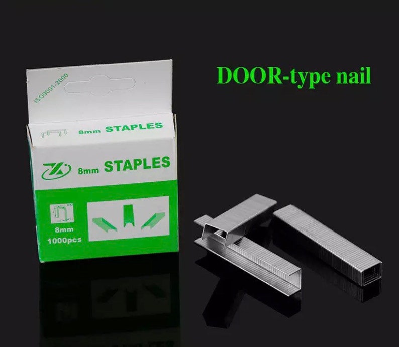 May include: A box of 8mm staples with the text "8mm STAPLES" in green and white. The box also has the text "1000pcs". Several loose staples are next to the box. The text "DOOR-type nail" is above the staples.