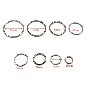 May include: Set of 8 silver metal rings in various sizes, ranging from 15mm to 50mm in diameter. The rings are smooth and have a polished finish.