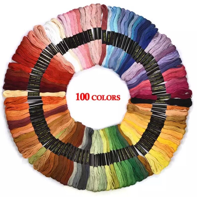 Puede incluir: Un conjunto de 100 carretes de hilo de bordar dispuestos en c&iacute;rculo, mostrando una amplia variedad de colores. Los carretes est&aacute;n etiquetados con "100 COLORES" en el centro.