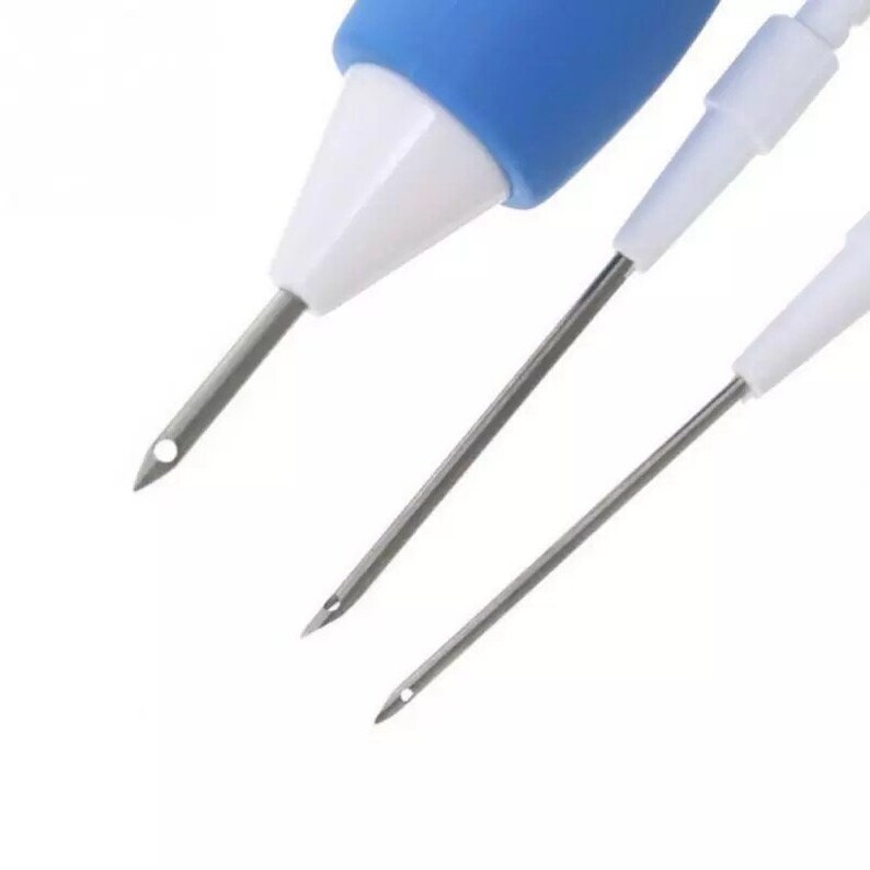 May include: Three needle threaders with blue and white plastic handles. The needles are made of metal and have a small hole at the tip.