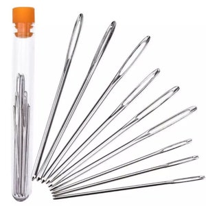 May include: A set of 10 assorted needles in a clear plastic tube with an orange lid. The needles are arranged in a fan shape.