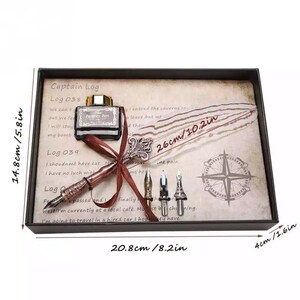 Pode incluir: Um conjunto de caligrafia numa caixa castanha com um design de b&uacute;ssola. O conjunto inclui uma pena de pena, um frasco de tinta e cinco pontas. A caixa mede 20,8 cm por 14,8 cm por 4 cm.
