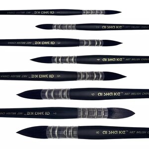 Op de afbeelding: Een set van acht zwarte penselen horizontaal gerangschikt, elk met een puntige donkere borstelpunt, een zilverkleurige metalen huls met geribbelde details en een zwarte steel bedrukt met de tekst AI SHA KE ART BRUSH CHINA en een maatnummer.