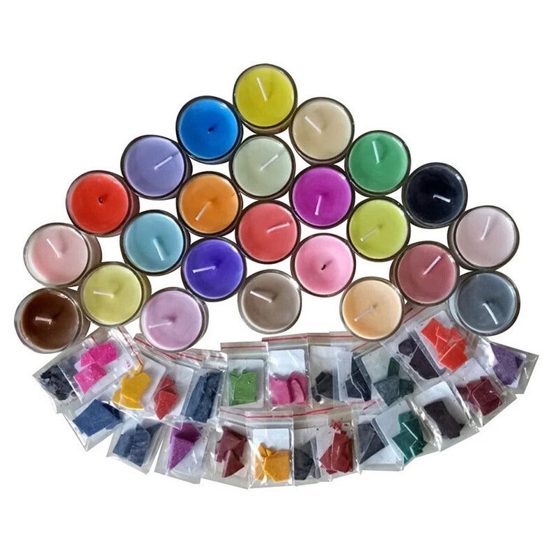 Puede incluir: Un juego de 24 velas de t&eacute; en varios colores, incluyendo rosa, amarillo, verde, azul y morado. Las velas est&aacute;n dispuestas en un semic&iacute;rculo, con peque&ntilde;as bolsas de escamas de cera de colores debajo.