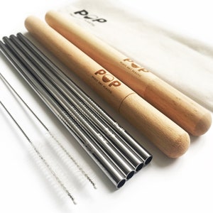 May include: Set of six silver reusable metal straws with a wooden carrying case. The case has the words "POP Peace Out Plastic" printed on it. The set also includes two cleaning brushes.