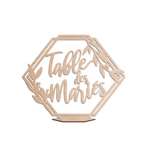 Puede incluir: Un letrero de número de mesa de madera con forma de hexágono geométrico y detalles florales. El letrero dice "Table des Maries".