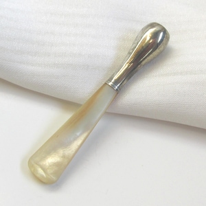 May include: A vintage silver-toned letter opener with a mother-of-pearl handle. The handle has a pearlescent sheen, transitioning from cream to light brown. The blade is silver, and the opener rests on a white surface.