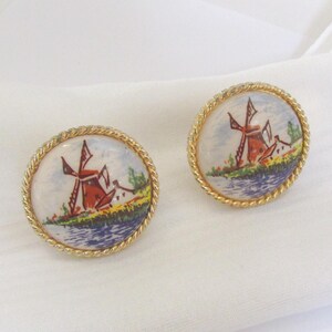 May include: A white ceramic mug with a black handle and the text "But First, Coffee" in a handwritten style. The mug is on a white surface. The mug is approximately 4 inches tall.