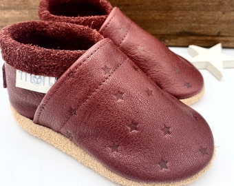 Leather crawling shoes for children in burgundy with embossed stars and statement lettering, children's slippers
