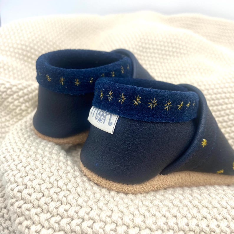 Der hintere Rand wird nach außen geschlagen und die raue Seite zeigt nach außen. Darunter befindet sich das Gummiband aus Naturelastik. Dadurch lassen sich die Schuhe leicht an- und ausziehen