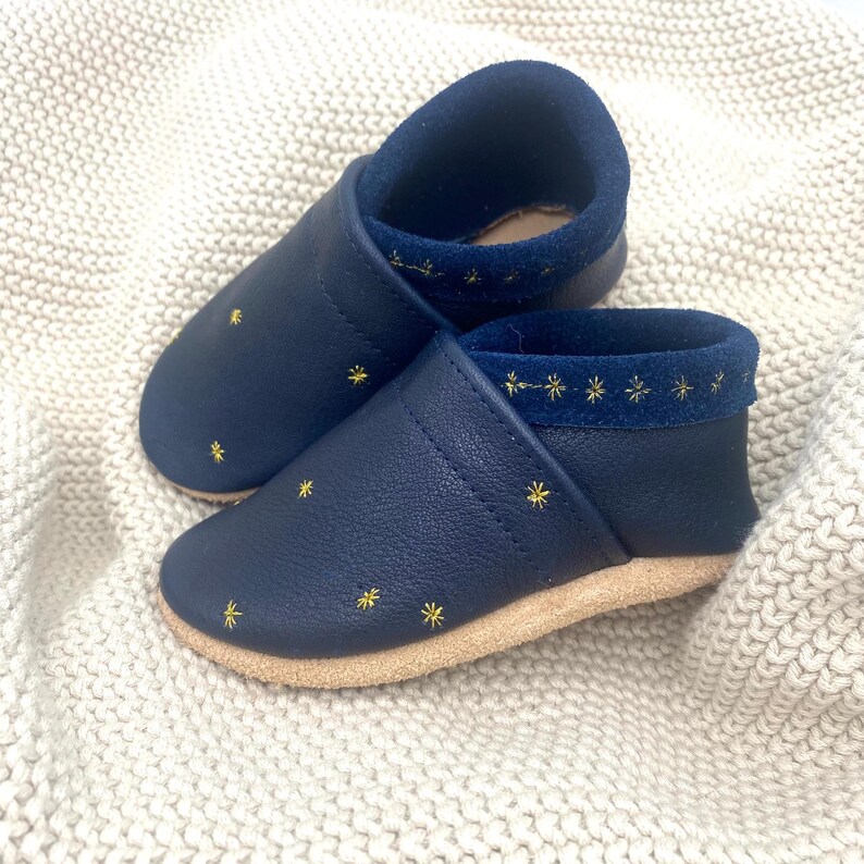 Mit liebevoll gestalteten, funkelnden Sternen verziert, bieten diese Schuhe nicht nur Komfort, sondern auch einen Hauch von Magie.