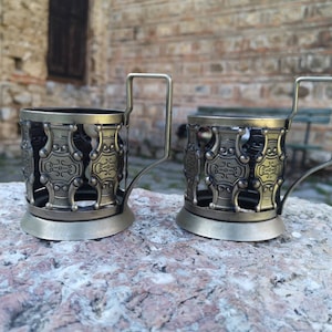 Two vintage tea cup holders, brass tea cup holders
