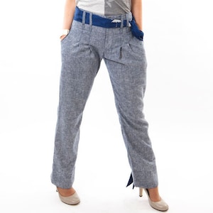 Puede incluir: Un pantalón de lino azul claro con un cinturón azul. El pantalón tiene un corte holgado y una longitud ligeramente recortada.