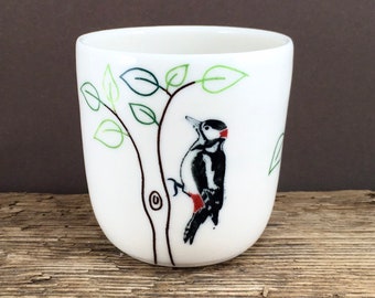 Ceramic cup made of porcelain with woodpecker